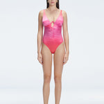 "Model wearing the Gradient Underwired Swimsuit with a ruched front and moderate bottom coverage, standing poolside."
