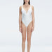 "Model wearing the Emma White Underwired Swimsuit with a ruched front and moderate bottom coverage, standing poolside."
