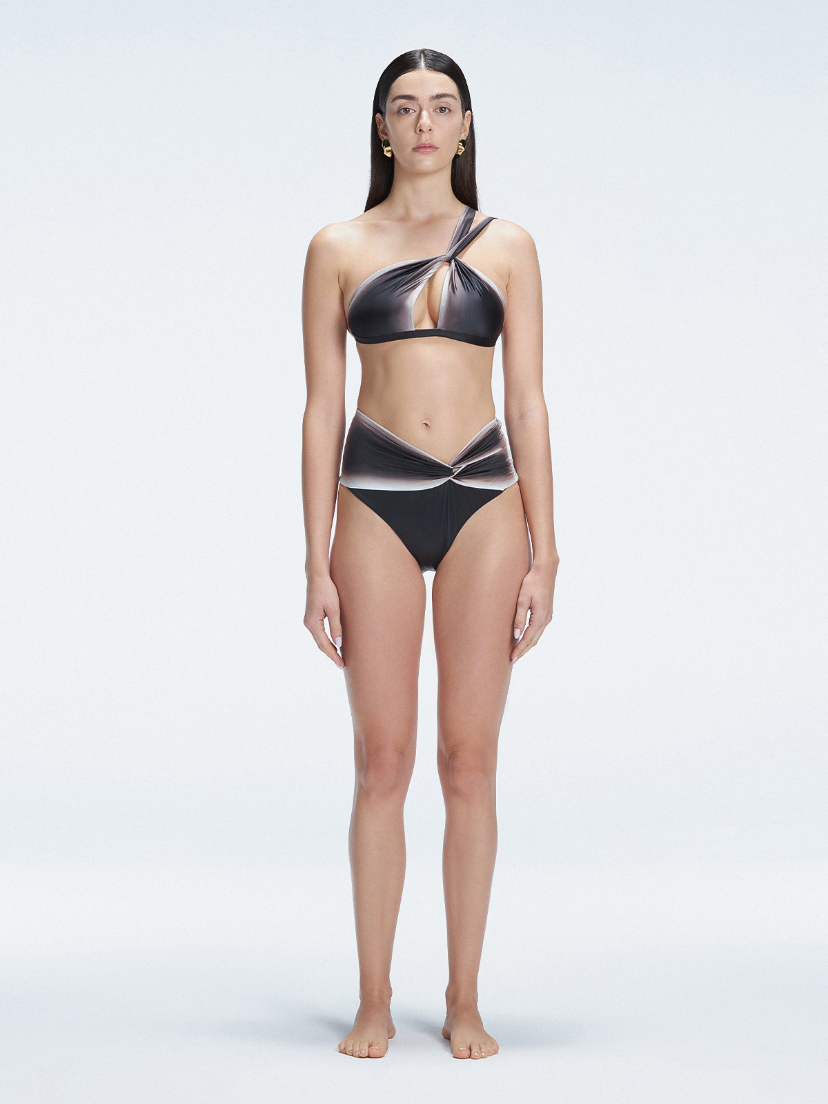 Front view of model wearing Eva Black Optical Bikini Set with one-shoulder design and vibrant printed fabric.
