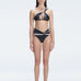 Front view of model wearing Eva Black Optical Bikini Bottom with high-waist cut and printed fabric.
