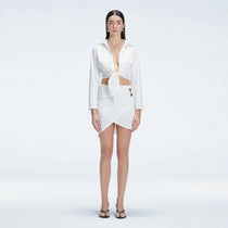 Greta White Long Sleeve Tie Front Shirt and Antonia White High-Waist Wrap Mini Skirt | Moeva | | Each week unveils new pieces—luxury swimwear, fluid resort silhouettes, and elevated summer-to-evening essentials designed to carry you from coastal escapes to city nights.