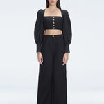 Front view of model wearing Gemma Black Cropped Top with blouson sleeves and sleek silhouette.
