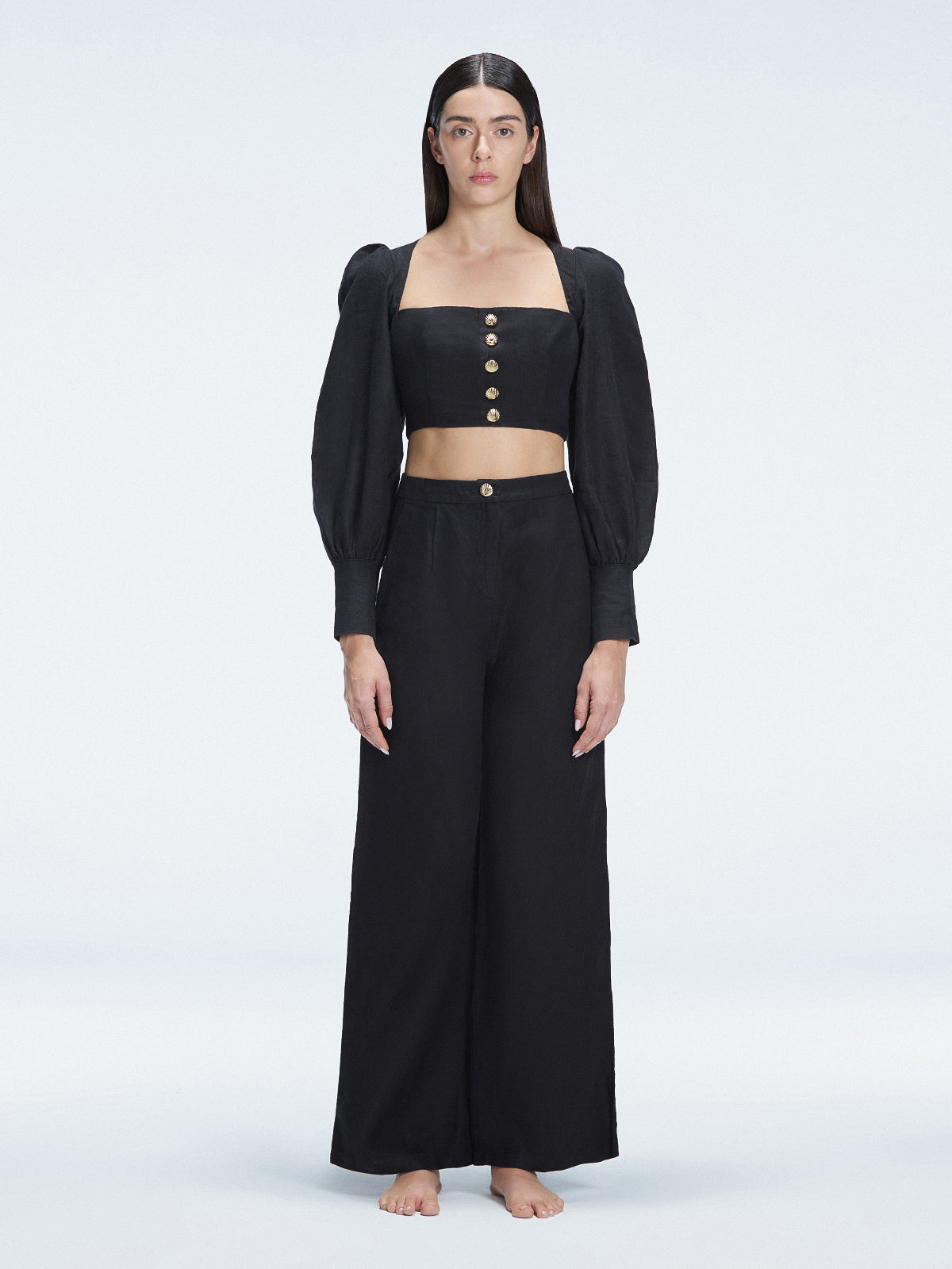 Front view of model wearing Gemma Black Cropped Top with blouson sleeves and sleek silhouette.
