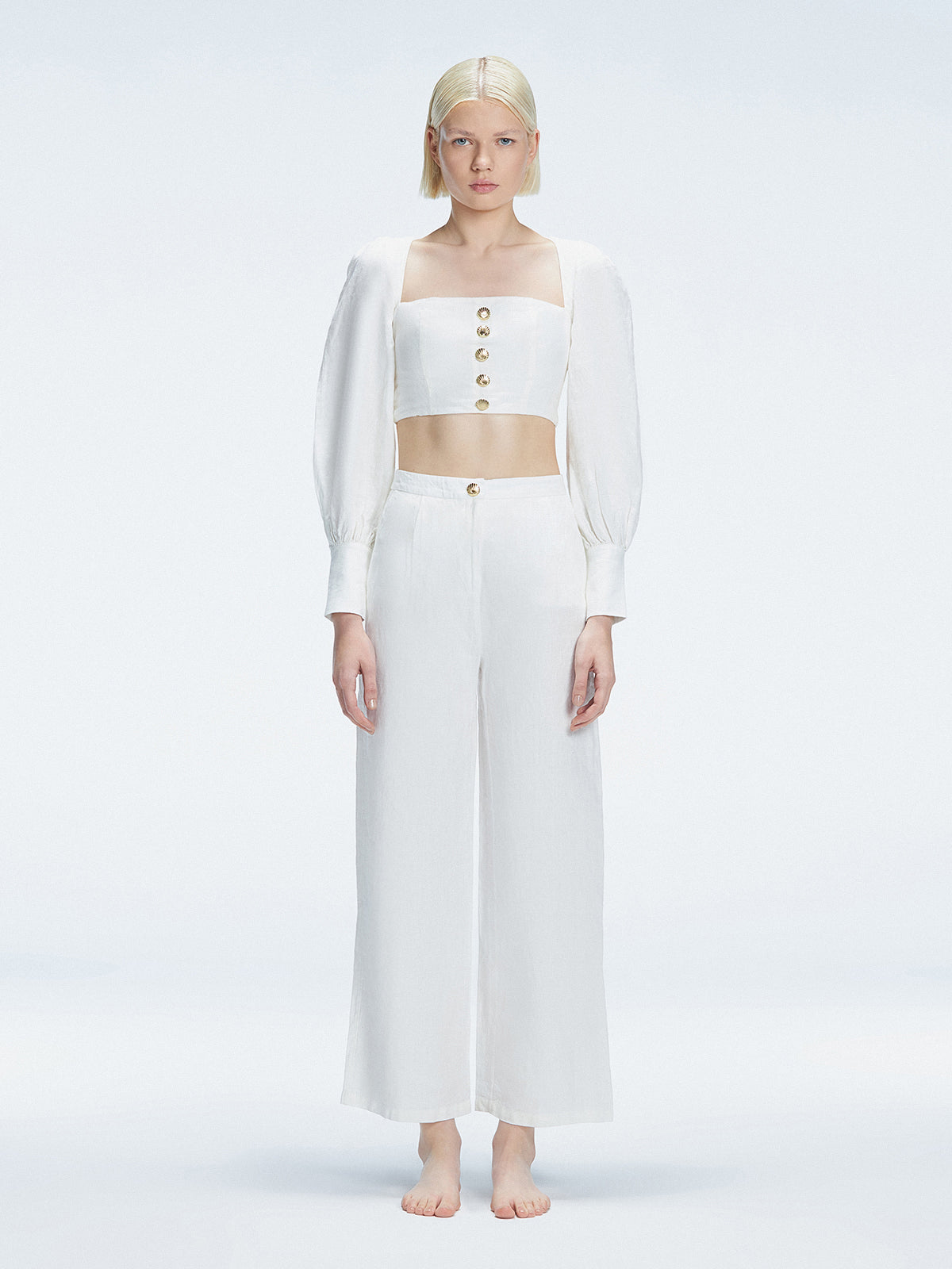 Front view of model wearing Gemma White Cropped Top with blouson sleeves and sleek silhouette.
