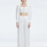 Front view of model wearing Valencia White Wide-Leg Pants with high-waisted fit and crisscross back straps.
