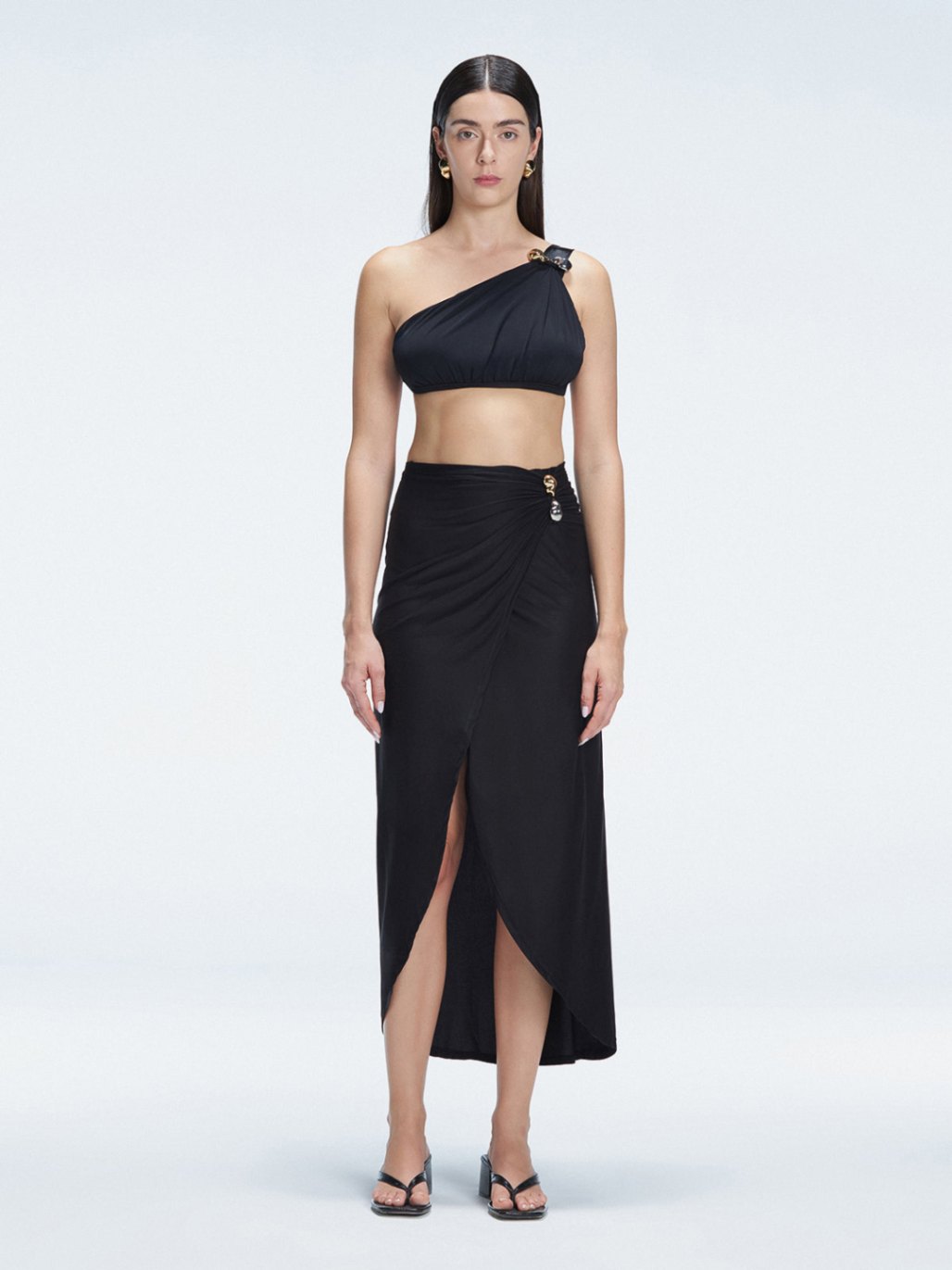 Front view of model wearing Gina Black Wrapped Skirt with flowing ankle-length design and front slip.
