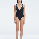 Front view of model wearing Griselda Black One Piece swimsuit with ruched body and deep V-neck.
