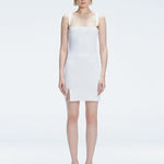 Front view of model wearing Heather White Mini Dress with square neckline, adjustable straps, and front slit.
