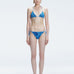 Front view of model wearing Hermione Blue Optical Bikini Bottom with low-waist cut and 3D printed design.
