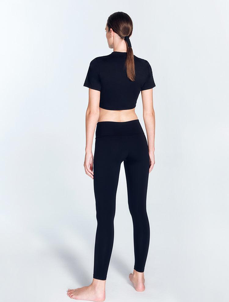 "Ida Black Leggings back view highlighting the ruched details and low waist design. The V-shaped waistline enhances the leggings' elegant look, while the stretchable material ensures comfort and flexibility."