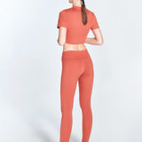 "Ida Red Ochre Leggings back view highlighting the ruched details and low waist design. The V-shaped waistline provides a flattering silhouette, while the stretchable material offers comfort and flexibility for various activities."