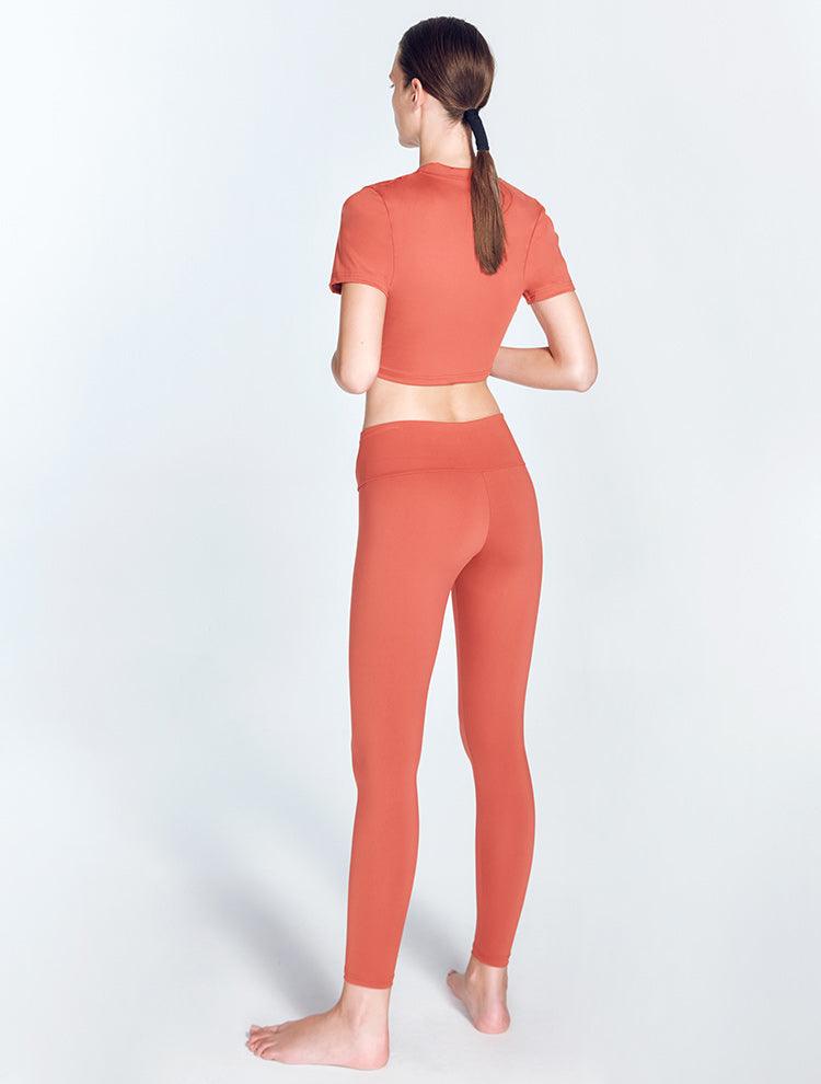 "Ida Red Ochre Leggings back view highlighting the ruched details and low waist design. The V-shaped waistline provides a flattering silhouette, while the stretchable material offers comfort and flexibility for various activities."