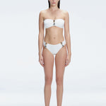 "Model wearing the Ilana White Bandeau Bikini Set with buckle and ruched detailing, posing by the pool."
