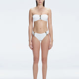 "Model wearing the Ilana White Bandeau Bikini Set with buckle and ruched detailing, posing by the pool."
