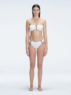 "Model wearing the Ilana White Bandeau Bikini Top with buckle and ruched detailing, posing by the pool."
