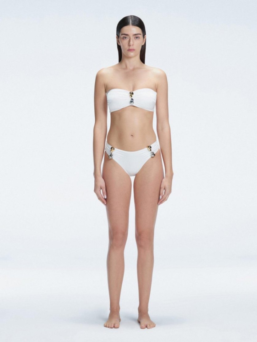 "Model wearing the Ilana White Bikini Bottom from the front, showcasing the chic bandeau style and elegant buckle detail."

