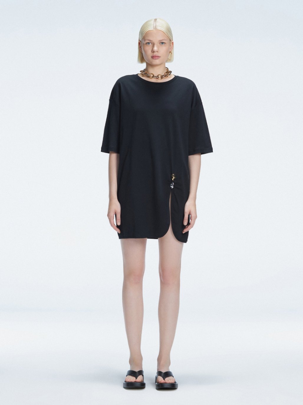 Front view of model wearing Lavinia Black Tee Dress with oversized fit and chic buckle detail.
