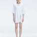 Front view of model wearing Lavinia White Tee Dress with oversized fit and chic buckle detail.
