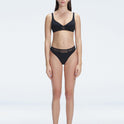 "Model wearing the Lorelai Black Bikini Bottom with a high-waisted design and mesh detail, posing by the pool."
