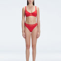 "Model wearing the Lorelai Red Bikini Top with a scoop neck and mesh detailing, posing by the pool."
