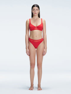 "Model wearing the Lorelai Red Bikini Top with a scoop neck and mesh detailing, posing by the pool."
