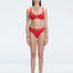 "Model wearing the Lorelai Red Bikini Top with a scoop neck and mesh detailing, posing by the pool."
