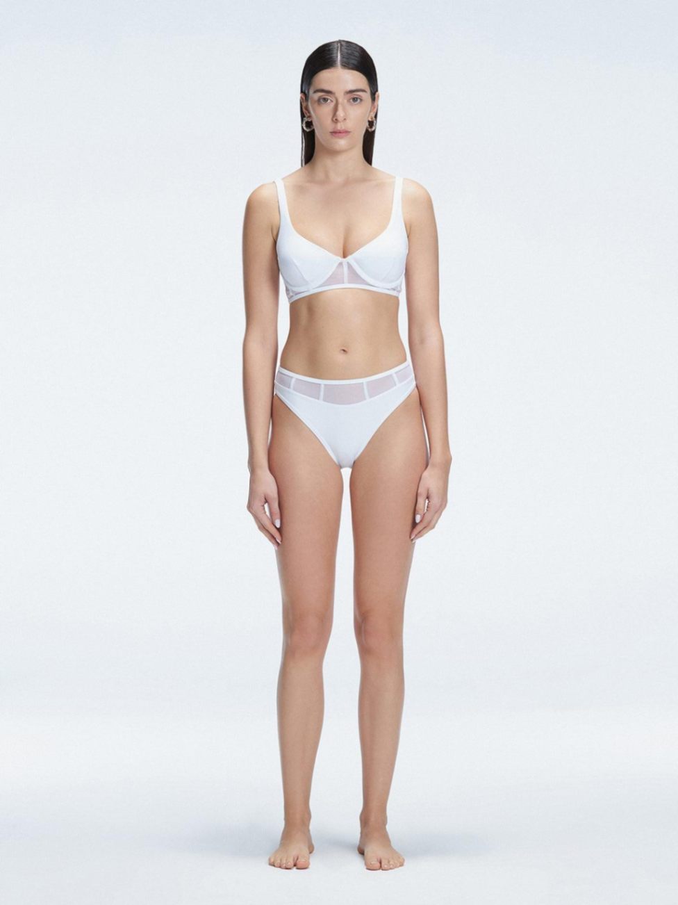 "Model wearing the Lorelai White Bikini Set with a high-waisted design and mesh detail, posing by the pool."
