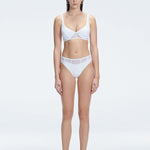 "Model wearing the Lorelai White Bikini Bottom with a high-waisted design and mesh detail, posing by the pool."
