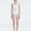 Model wearing the Lyra White Underwired Swimsuit with ruched front and moderate bottom coverage.
