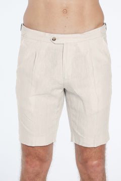 Beige shorts worn by a person on a white background