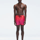 Model wearing Griffin Red Gradient Swim Shorts with pink-red print and sporty piping.