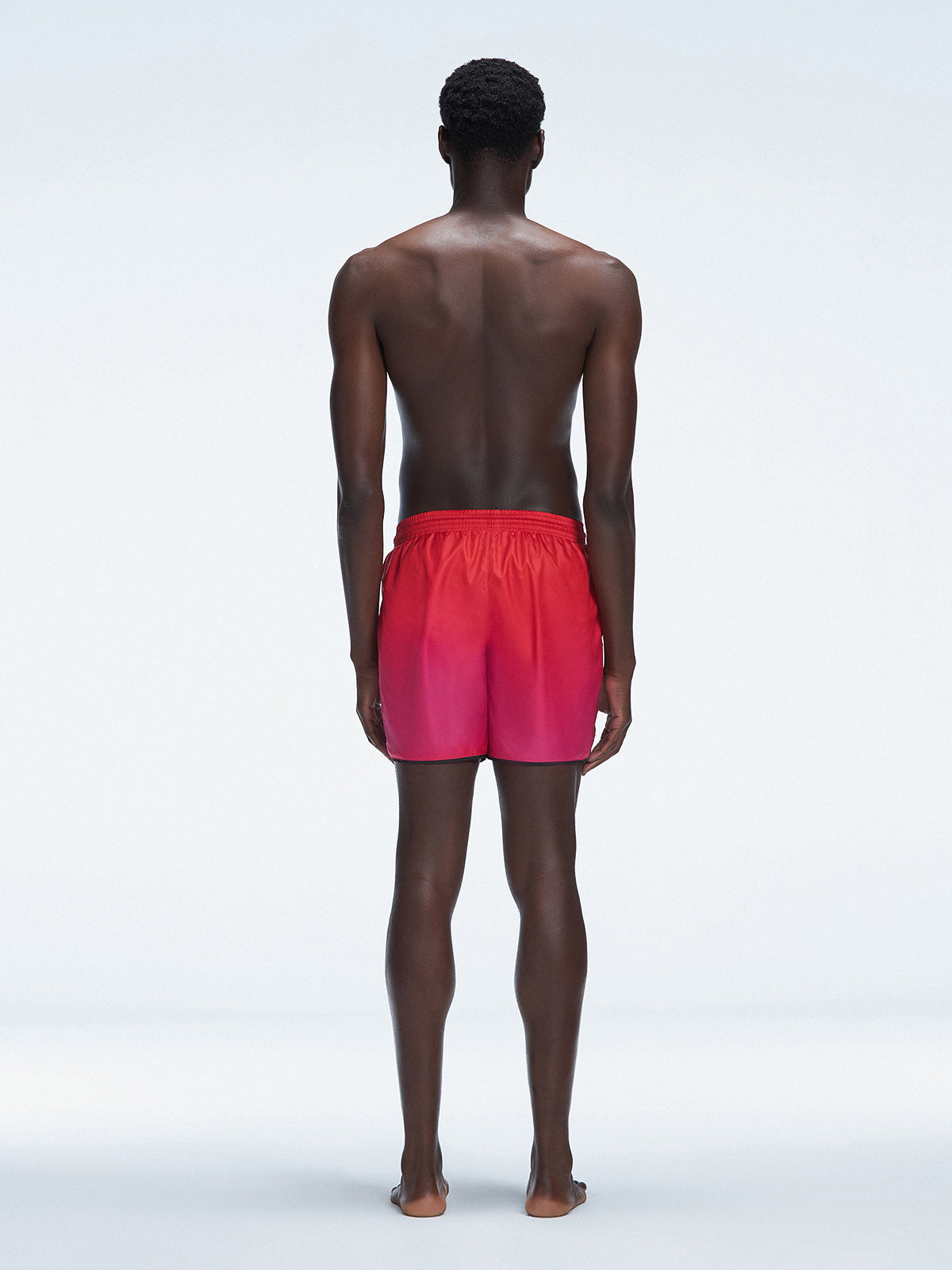 Back view of Griffin Red Gradient Swim Shorts, highlighting the bold pink-red gradient and comfortable fit.
