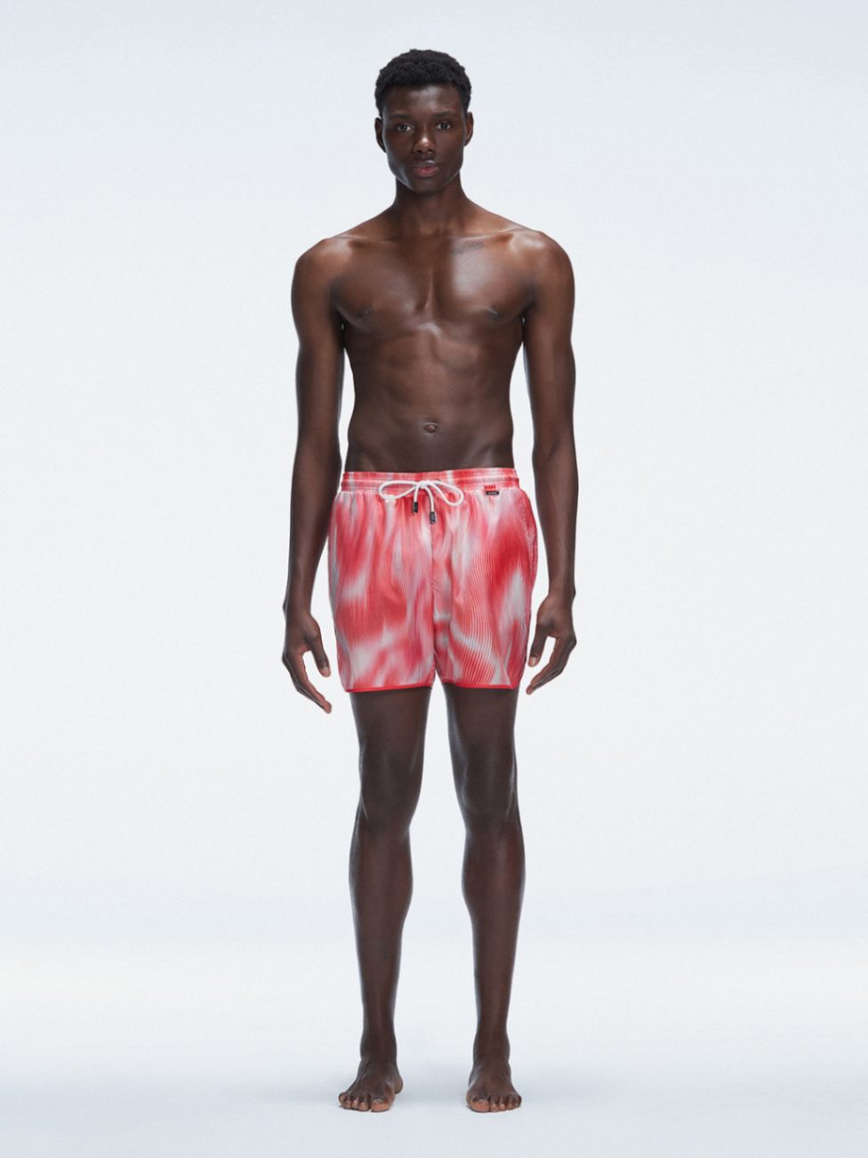 Model wearing Griffin Red Sonar Swim Shorts with printed fabric and sporty side piping.