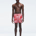 Model wearing Griffin Red Sonar Swim Shorts with printed fabric and sporty side piping.