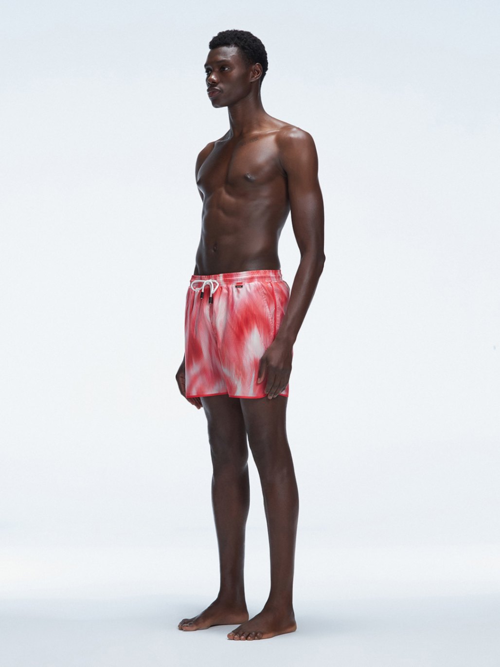 Model showcasing Griffin Red Sonar Swim Shorts with side piping detail and a secure elastic waistband.
