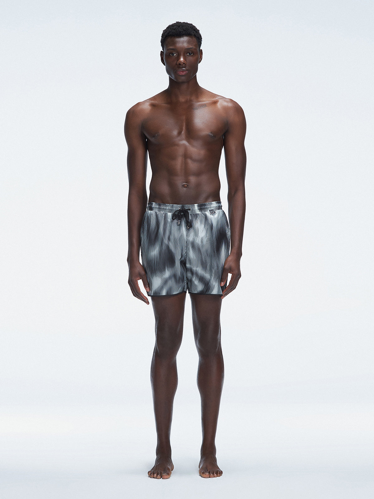 Model wearing Griffin Black Sonar Swim Shorts with elastic waistband and piping detail.