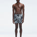 Model wearing Griffin Black Sonar Swim Shorts with elastic waistband and piping detail.