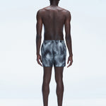 Back view of model wearing Griffin Black Sonar Swim Shorts, showcasing the bold black print and comfortable fit.
