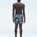 Back view of model wearing Griffin Black Sonar Swim Shorts, showcasing the bold black print and comfortable fit.
