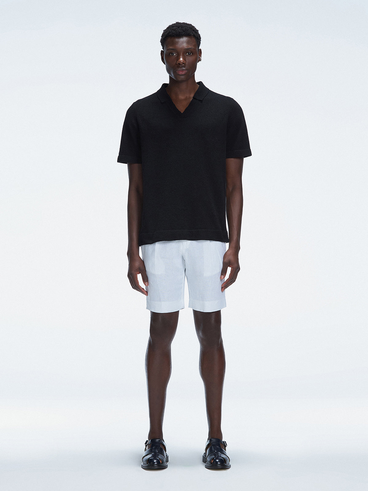 Model wearing Atticus Black Polo T-Shirt with open collar and slim fit.