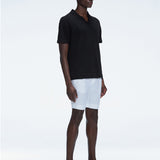 Side view of the Atticus Black Polo T-Shirt on a model, highlighting the open collar and sleek, tailored fit.
