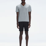 Model wearing the Atticus Grey Polo T-Shirt with a slim fit and open collar, standing in a casual outdoor setting.
