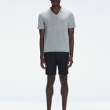 Model wearing the Atticus Grey Polo T-Shirt with a slim fit and open collar, standing in a casual outdoor setting.
