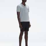 Side view of the Atticus Grey Polo T-Shirt on a model, highlighting the sleek open collar and short sleeves.
