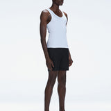 Side view of the model wearing the Phillip White Tank Top, highlighting the sleeveless design and sleek fit.
