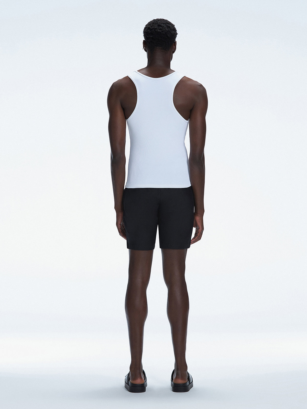 Back view of the model in the Phillip White Tank Top, showcasing the tailored silhouette and clean design.
