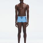 Model wearing Antonio Baby Blue/Blue Swim Trunks with a tight, form-fitting design.
