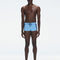 Model wearing Antonio Baby Blue/Blue Swim Trunks with a tight, form-fitting design.
