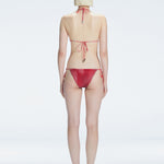 Back view of model wearing Hermione Red Optical Bikini Top, highlighting the adjustable back ties and sleek fit.
