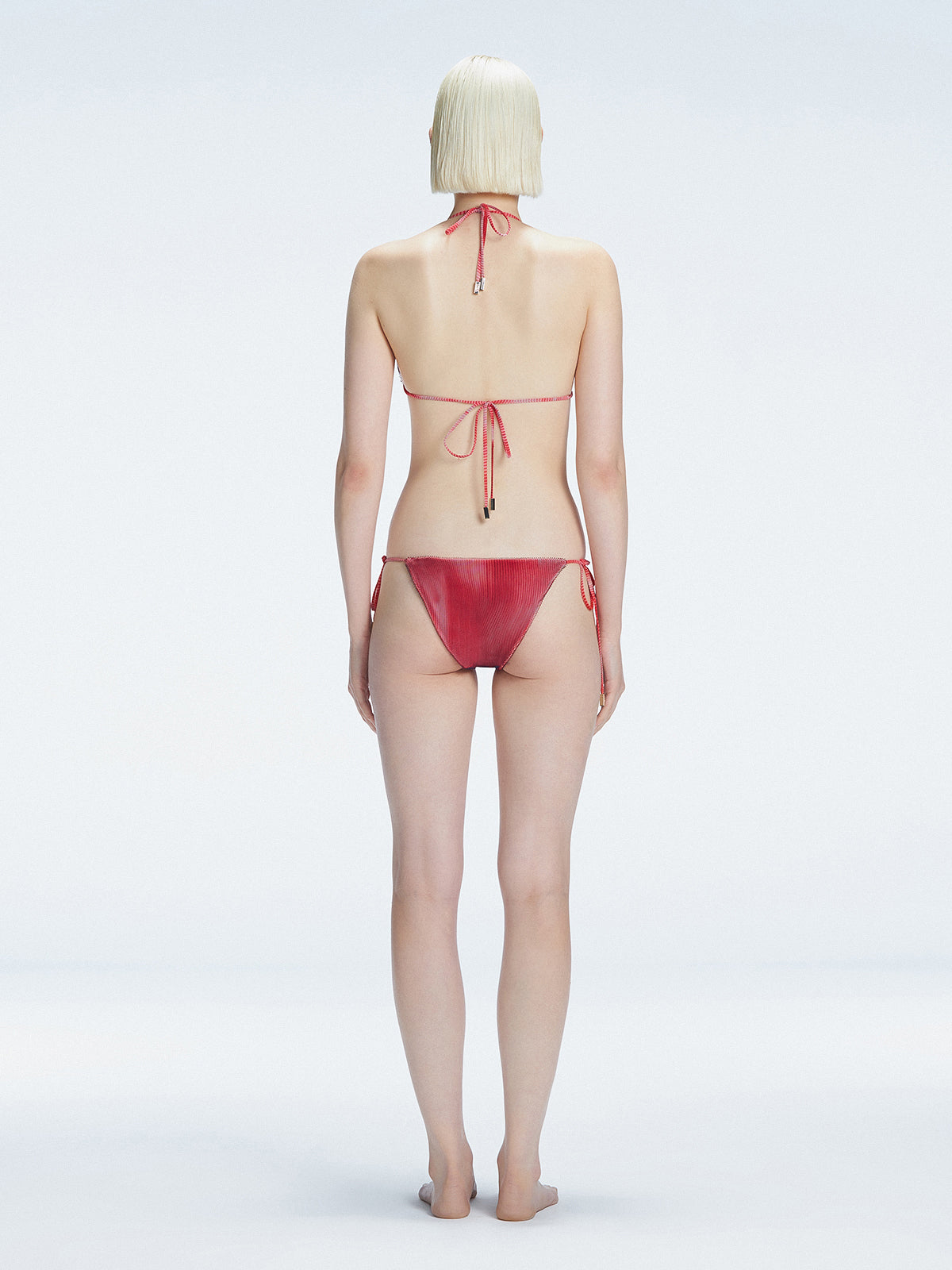 Back view of model wearing Hermione Red Optical Bikini Top, highlighting the adjustable back ties and sleek fit.
